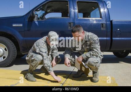 SrA Mike Vasilakos Engineering Assistant, 108 Bauingenieur Geschwader, und Tech. Sgt. Sean Joseph, Operations Manager, 108 Bauingenieur Squadron, Prüfen und Dokumentieren einen Riss in der Zement der 108 Flugzeuge parken Rampe, ohne ordnungsgemäße Wartung hat das Potenzial zu erstellen FOD (Foreign Object Ablagerungen) und ein Flugzeug beschädigt werden. Stockfoto
