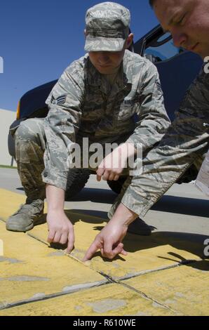 SrA Mike Vasilakos Engineering Assistant, 108 Bauingenieur Geschwader, und Tech. Sgt. Sean Joseph, Operations Manager, 108 Bauingenieur Squadron, Prüfen und Dokumentieren einen Riss in der Zement der 108 Flugzeuge parken Rampe, ohne ordnungsgemäße Wartung hat das Potenzial zu erstellen FOD (Foreign Object Ablagerungen) und ein Flugzeug beschädigt werden. Stockfoto