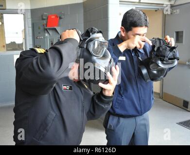 Region der Großen Seen, Il. (02.Mai 2017) Cmdr. Jorge Toso, chilenischen Marine, und Cmdr. Felipe Imamura, brasilianischen Marine, versuchen Sie auf Gasmasken während einer ausländische Offiziere Tour auf der USS Chief, Brandbekämpfung Trainer rekrutieren, 2. Mai, um das Training der Befehl rekrutieren. Der Besuch umfaßt vier älteren ausländischen Verbindungsbeamten, Mitglieder von US-Flotte Kräfte Befehl, RTC und Training Support Center über einen dreitägigen Zeitraum tourte. Die Offiziere wurden Vertreter der Mexikaner, Brasilianer, chilenischen und peruanischen Seestreitkräfte. Über 30,000-40,000 Rekruten Absolvent jährlich nur von Boot Camp der Marine. Stockfoto