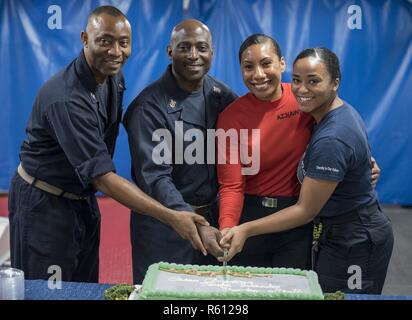 Arabischen Golf (6. Mai 2017) von links nach rechts, LT Salomo Lloyd, Command Master Chief Huben Phillips, Aviation Maintenance Administrationman 3. Klasse Pauline Dyer, und Hospital Corpsman 3. Klasse Terra Lamm den Kuchen für asiatische American Pacific Islander Geschichte Monat Einhaltung an Bord der Flugzeugträger USS George H.W. Schnitt Bush (CVN 77) (GHWB). GHWB ist in den USA der 5. Flotte Bereich für Maßnahmen zur Erhöhung der Sicherheit des Seeverkehrs auf die Verbündeten und Partnern zu beruhigen bereitgestellt, und der Freiheit der Schiffahrt und des freien Handels in der Region erhalten. Stockfoto