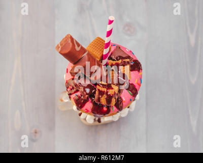 Freakshake mit Donuts auf grau Holz- Hintergrund Stockfoto