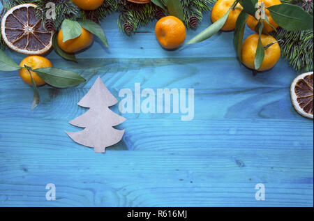 Blick von oben auf die Papier Weihnachtsbaum auf blauem Hintergrund aus Holz mit Zitrusfrüchten Rahmen eingerichtet Stockfoto