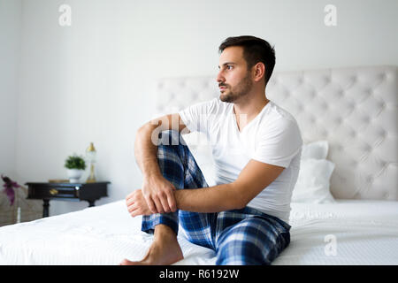 Portrait von unglücklichen Mann sitzt auf dem Bett Stockfoto