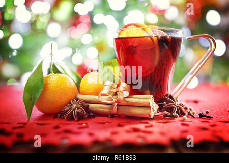 Weihnachten Hintergrund mit heißem Glühwein, Orangen, Cinnamon Sticks vor Baum Stockfoto