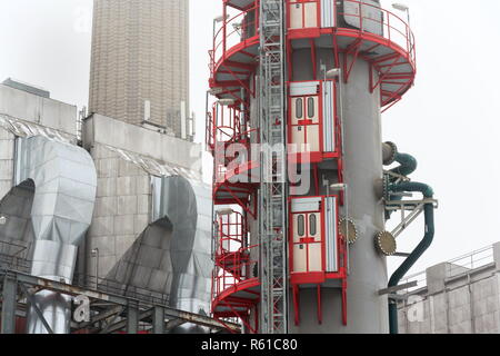 Alten eine neue Schornsteine am Heizwerk in Nebel, trüben Wintertag, Low Angle View, Energie, Klimawandel und globale Erwärmung Konzept Stockfoto
