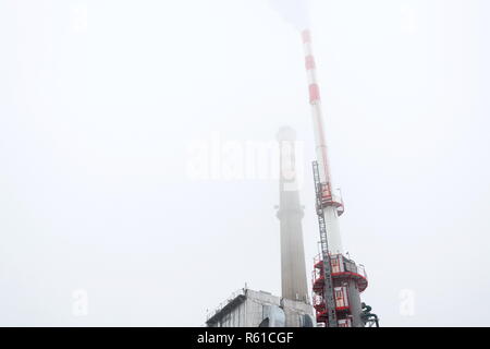 Alten eine neue Schornsteine am Heizwerk in Nebel, trüben Wintertag, Low Angle View, Energie, Klimawandel und globale Erwärmung Konzept Stockfoto
