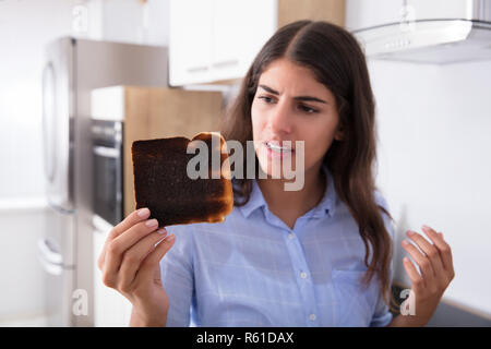 Traurige Frau mit Toast gebrannt Stockfoto