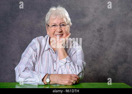 Grau behaarte ältere Frau auf der Suche entspannt Stockfoto