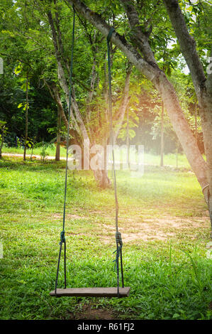 Schwingen auf dem Baum im Sommer Garten/alte Schaukel Werkbank mit Holz- Stockfoto