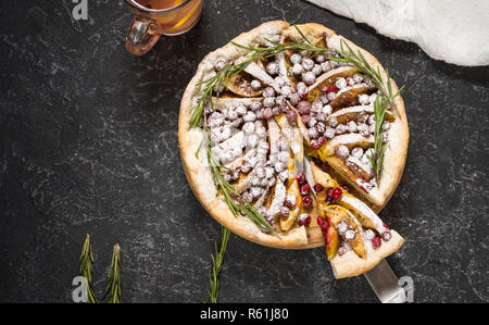 Apfelkuchen mit Cranberry und Tasse Tee auf schwarzen Stein Hintergrund. Ansicht von oben Stockfoto