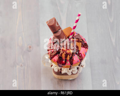 Freakshake mit Donuts auf grau Holz- Hintergrund Stockfoto