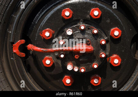 Bunte Muttern und Schrauben auf einem LKW-Reifen Stockfoto