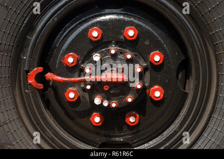 Bunte Muttern und Schrauben auf einem LKW-Reifen Stockfoto