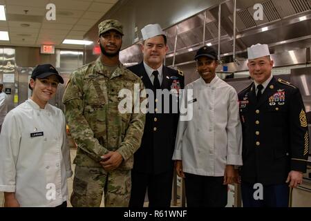 Generalmajor Willard Burleson und Command Sgt. Maj. Stephen Helton treffen Food Service Spezialisten während des Thanksgiving Essen Service das Raptor Nest Dining Facility, Joint Base Lewis-McChord, Washington, November 21, 2018. Zu Ehren der dankt die Soldaten der Einheit, Senior Leaders serviert Essen für die Soldaten. Stockfoto