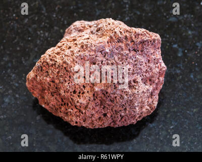 Pebble rot Bimsstein auf dunklem Hintergrund Stockfoto