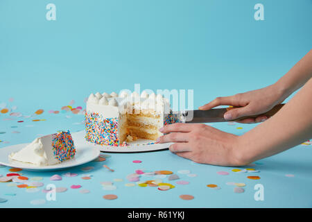 Teilweise mit Blick auf die Frau, die leckeren Kuchen auf blauem Hintergrund Stockfoto