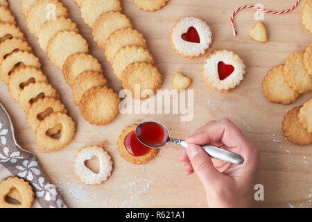 Blick von oben auf die traditionelle weihnachtliche Linzer Plätzchen mit Erdbeermarmelade auf Holzbrett gefüllt. Diese sind traditionelle österreichische gefüllt Gebäck. Stockfoto