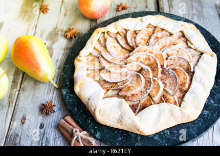 Kuchen mit Äpfeln, Birnen und Zimt auf einem alten hölzernen Hintergrund Stockfoto