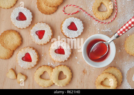 Blick von oben auf die traditionelle weihnachtliche Linzer Plätzchen mit Erdbeermarmelade auf Holzbrett gefüllt. Diese sind traditionelle österreichische gefüllt Gebäck. Stockfoto