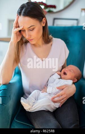 Betonte Mutter Holding Baby Schreien von postnatalen Depressionen leiden zu Hause Stockfoto