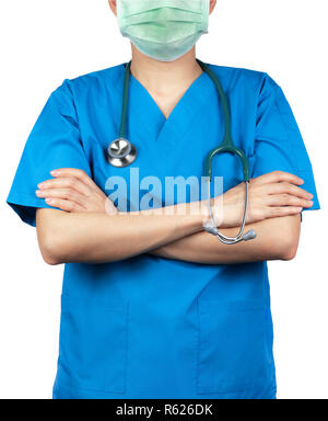 Chirurg Arzt tragen blaue scrubs Shirt einheitliche und grünen Gesichtsmaske. Arzt stand mit verschränkten Armen und Hand Stethoskop. Healthcare professi Stockfoto