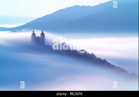 Über Wolken in Banska Stiavnica, Slowakei Kalvarienberg Stockfoto