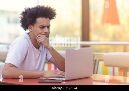 Bild der afrikanischen amerikanischen Geschäftsmann auf seinem Laptop arbeiten. Hübscher junger Mann an seinem Schreibtisch. Stockfoto