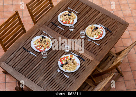 Leckere italienische Spaghetti pasta Dinner mit Caprese Salat auf Holztisch, Ansicht von oben. Essen Konzept Stockfoto