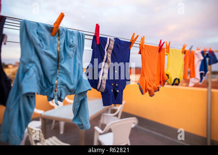 Bunte Kleidung hängend am Seil in der Linie Stockfoto