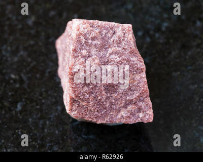 Raw rosa Quarzit Stein auf dunklem Hintergrund Stockfoto