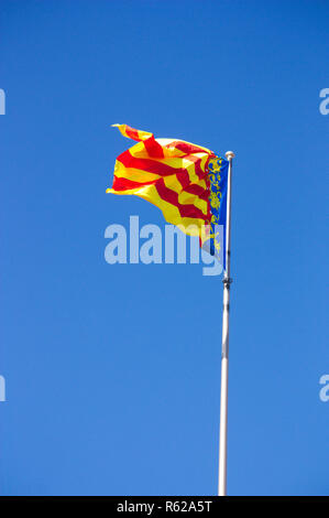 Der Flagge der Gemeinschaft Valencia auf einem Mast, während die im Wind flattern mit einem blauen Hintergrund der Sommer sky Stockfoto