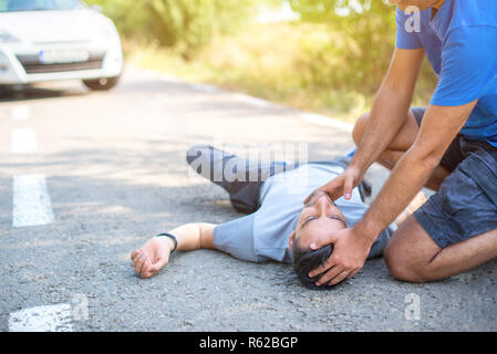 Mann, erste Hilfe bei Autounfall Stockfoto