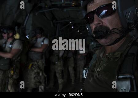 Master Sgt. Bruce Slamin, ein 81Th Expeditionary Rescue Squadron Suche und Rettung Lademeister, hört Radio anrufen, bevor eine statische Zeile springen von einer HC-130 P König in der Nähe von Camp Lemonnier, Dschibuti, 4. Mai 2017. Der 81st ERQS wurde profiding Luftbrücke pararescue Flieger der 82nd ERQS. Stockfoto