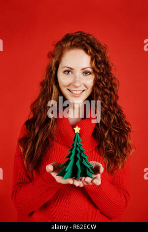 Lächelnde Mädchen einen kleinen Weihnachtsbaum Stockfoto