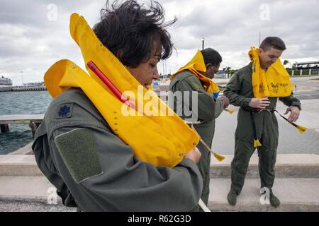 Us Air Force Oberstleutnant Rosa Ramos, Links, Tech. Sgt. Khary A. Jagd, Mitte, und Kapitän James McGee, alle mit der 514Th Aeromedical Evacuation Squadron, 514Th Air Mobility Wing, Don ihre Schwimmwesten für Wasser überlebenstraining an der Naval Air Station in Key West Truman Hafen, Key West, Fla., Nov. 16, 2018. Die 514Th ist ein Air Force Reserve Command Unit bei Joint Base Mc Guire-Dix - Lakehurst, N.J. entfernt Stockfoto