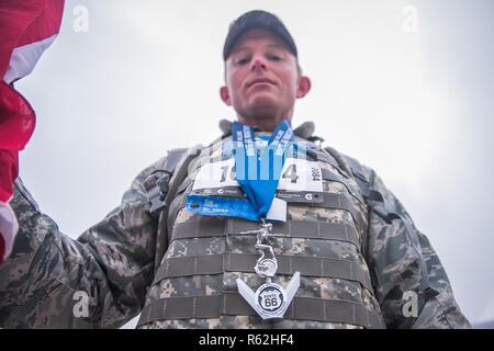 Tech Sgt. Cory Shaw, ein Recruiter auf die 138 Fighter Wing, Tulsa, Oklahoma, zeigt seine Route 66 Halbmarathon Medaille Nov. 18, 2018 im Williams Route 66 Marathon, Tulsa, Oklahoma. Die Medaille wird von einem 1930er Jahre Bugatti hood Emblem inspiriert, während die V-förmige Grundplatte ehrt Tulsa das pulsierende Art déco-Geschichte. Stockfoto