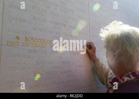 Alexandra Bonnyman Prejean, Tochter von Ehrenmedaille Empfänger US Marine Corps 1. Lt Alexander Bonnyman, Orte eine American Battle Monuments Commission (AMBC) Rosette neben dem Namen Ihres Vaters während einer Umwidmung Zeremonie an der Nationalen Gedenkstätte Friedhof der Pazifik, Honolulu, Hawaii, 19.11.2018. Die Rosette zeigt ein service Mitglied, dessen bleibt eingezogen wurden und zurückgegeben. Bonnyman's Überreste wurden im Jahr 2015 erholt. 1. Lt. Bonnyman kämpften und gab sein Leben für sein Land während der Schlacht um Tawara; für seine Tapferkeit und Aktionen während der Schlacht, war er der Med belohnt Stockfoto