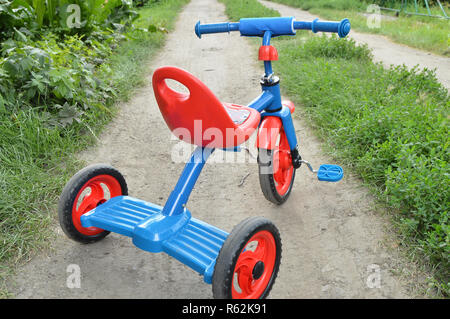 Dreirad Kinderfahrrad Fahrrad blau und rot Neu ist auf der Straße in den Garten Kinder zu unterhalten Stockfoto