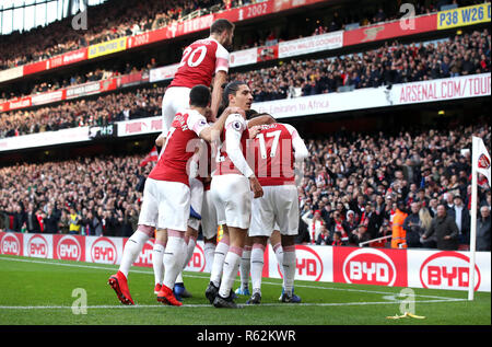 Von Arsenal Pierre-Emerick Aubameyang (verdeckt) feiert ersten Ziel seiner Seite des Spiels zählen vom Elfmeterpunkt mit Teamkollegen, wie eine Bananenschale auf dem Spielfeld durch einen Ventilator geworfen, während der Premier League Match im Emirates Stadium, London. Stockfoto