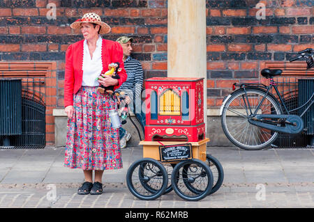 Bremen, Deutschland - 11. Juni 2011: Street Artist in nationalen Kleid mit Affen doll stehen in der Nähe der Straße Orgel Stockfoto