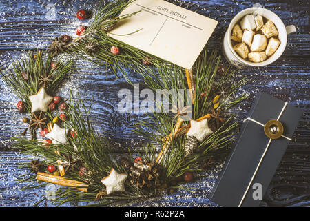 Adventskranz mit Postkarte und Gegenwart auf der hölzernen Hintergrund-Draufsicht Stockfoto