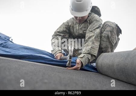 Senior Airman Minh Dinh, Mitglied der Task Force Phoenix, Hammer Nägel in Dachschindeln bei Tyndall Air Force Base, Fla., Nov. 24, 2018. Dinh ist Mitglied der Task Force Phoenix, die Navy Seabees, Armee Korps der Ingenieure, RED HORSE Staffeln und Bauingenieure über von den Vereinigten Staaten bestand. Dinh ist aus dem 19. Bauingenieur Squadron an Little Rock Air Force Base, Arche bereitgestellt Stockfoto