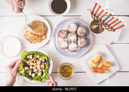 Traditionelle Hanukkah Gerichte auf die weiße Holztisch, Ansicht von oben Stockfoto