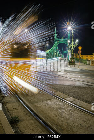 Budapest, Ungarn - festlich geschmückten Licht Straßenbahn (Fenyvillamos) unterwegs an der Freiheitsbrücke (szabadság Hid) in der Nacht. Weihnachten in Budapest Stockfoto