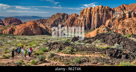 Wanderer am Lavastrom Trail, Basalt vulkanischen Felsen und Navajo Sandstein Felsformationen, bei Snow Canyon State Park, Utah, USA Stockfoto