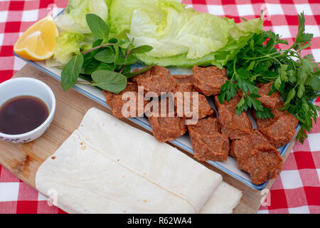 Traditionelle türkische Vorspeise Cigkofte mit lavash, Zutaten sind roh, Fleisch Bulgur, Zwiebeln, Tomatenmark, Chili, Salz und Pfeffer. Hohen Winkel 7/8 v Stockfoto