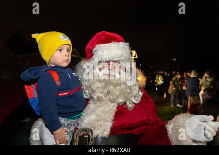 Warrington, Cheshire, UK. 02. Dezember 2018 - Die Gemeinschaft der Walton in der Nähe von Warrington, Cheshire, England, sammelten für ihre jährliche Einschalten der Weihnachtsbaumbeleuchtungen. Weihnachtslieder wurden von Mitgliedern der St John's Kirche gesungen und die Kinder waren begeistert, als der Weihnachtsmann seinen Terminkalender durch und biegen Sie an der Ampel der Credit: John Hopkins/Alamy Live News drop Links Stockfoto