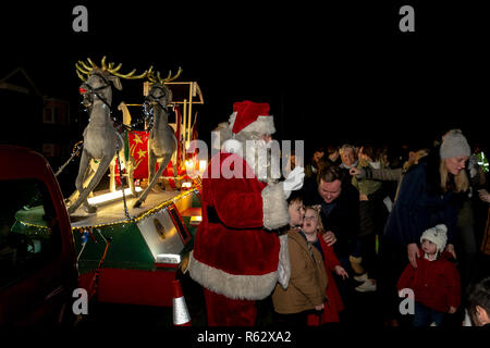 Warrington, Cheshire, UK. 02. Dezember 2018 - Die Gemeinschaft der Walton in der Nähe von Warrington, Cheshire, England, sammelten für ihre jährliche Einschalten der Weihnachtsbaumbeleuchtungen. Weihnachtslieder wurden von Mitgliedern der St John's Kirche gesungen und die Kinder waren begeistert, als der Weihnachtsmann seinen Terminkalender durch und biegen Sie an der Ampel der Credit: John Hopkins/Alamy Live News drop Links Stockfoto