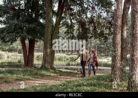 Junge Paare sind, Wandern mit Hund im Wald Stockfoto