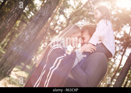 Junge Eltern mit kleinen Tochter im Herbst Wald. Close-up Family Portrait Stockfoto